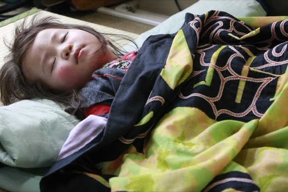 笹本恒子写真賞を受賞した宇井真紀子さんの作品。アイヌ文様の刺繍が入った着物をかけて、工芸品展示会会場の片隅で眠る女の子。（2008.4.26）