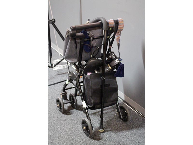 喜美子さん愛用の手押し車。デジタル一眼レフカメラが掛けられていた。