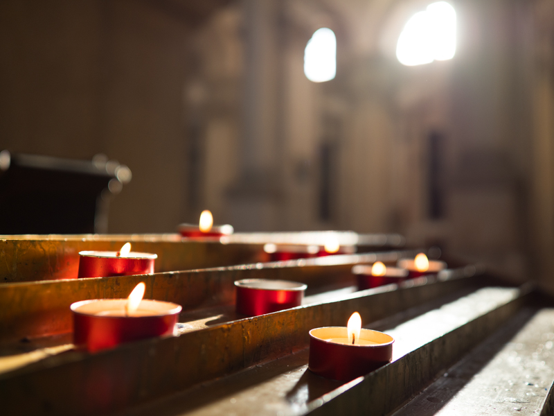 教会の窓から差し込む光が燭台に当たってロウソクのあかりと交差していた。ロウソクの1つに思い切り近接して開放絞りで背景をぼかすと、ボケのなめらかさを実感できる。<br><span class="fnt-85">OLYMUS OM-D E-M1 MarkII / M.ZUIKO DIGITAL ED 17mm F1.2 PRO / 17mm（34mm相当） / 絞り優先AE(F1.2、1/350秒、±0EV)/ ISO 200</span>