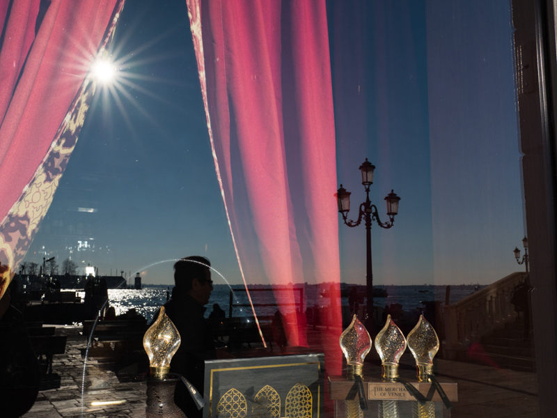 フェリー乗り場に面した老舗ホテルのレストランに反射する光景を絞り込んで撮影。航行する船舶や目の前を行き交う人々。ガラス窓に映る光景はいつまで見ていても飽きない。<br><span class="fnt-85">OLIMPUS OM-D E-M1 Mark II / M.ZUIKO DIGITAL ED 17mm F1.2 PRO / 17mm（34mm相当） / 絞り優先AE（F8、1/500秒、-0.5EV） / ISO 200</span>