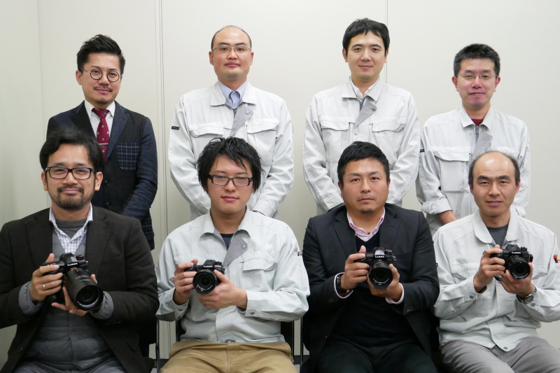 パナソニック株式会社アプライアンス社の面々。前列左からAP社直轄デザインセンター パーソナルデザイン部 PA3課 主任意匠技師の佐々木厚氏(デザイン)、商品設計部 商品設計三課 主任技師の堀江悟史氏(開発リーダー)、商品企画部 第一商品企画課 主務の角和憲氏(商品企画)、外装設計部 外装設計二課 係長の玉置亮輔氏(外装設計)、後列左から商品企画部 第一商品企画課 主務の渡邊慎治氏(レンズ企画)、ソフト設計部 ソフト設計六課 課長の澁野剛治氏(AF)、商品設計部 商品設計二課 主任技師の岡本晃宏氏(画質設計)、ソフト設計部 ソフト設計六課 係長の櫻井幹夫氏(手ブレ補正)
