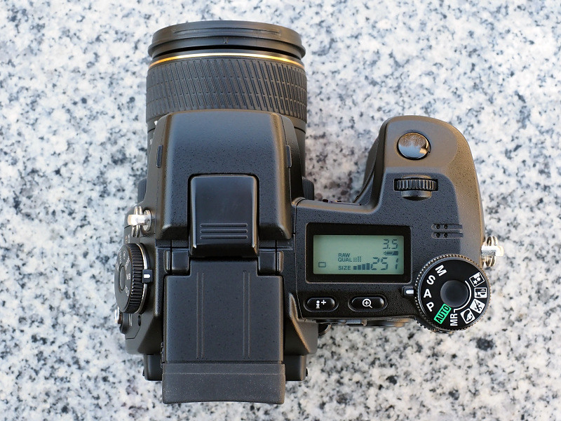 DiMAGE A2は左手側の側面がカッコイイが、上面部もなかなか。存在感ありまくりのチルト式の電子ビューファインダーと、イルミネーター機能付きのデータパネルがいかす。