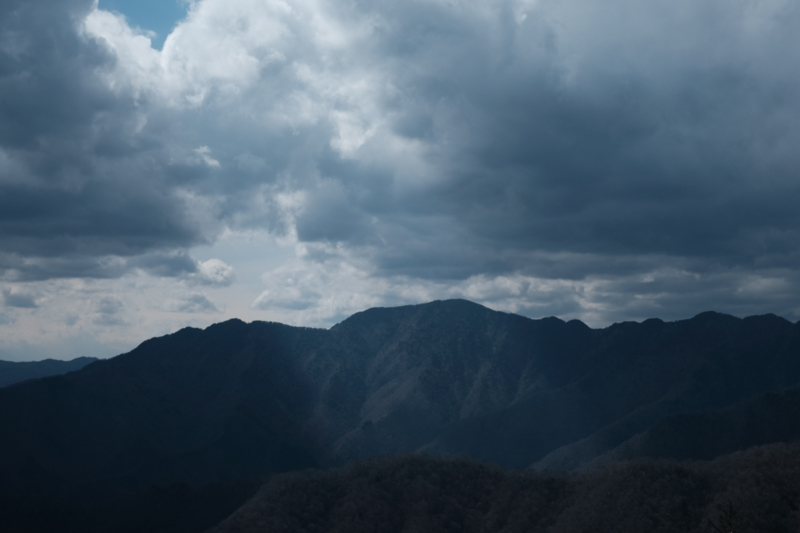 山梨側から雲取山へ向かう稜線上にある飛龍山を望む。雲間から光が射して神々しい。「雲取山」の山名の由来のように本当に雲に手が届きそうだ。<br><span class="fnt-85">X-H1 / XF35mmF1.4 R / 35mm（53mm相当） / 絞り優先AE（1/600秒・F11・-0.7EV） / ISO 200</span>
