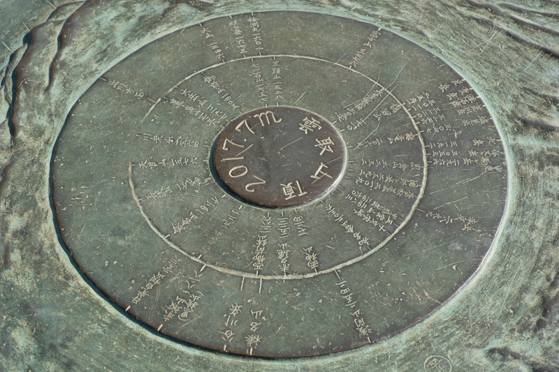 雲取山頂にあった銅板のプレート。360度、全方位の山々を表している。それぐらい雲取山頂からの見晴らしは素晴らしい。<br><span class="fnt-85">X-H1 / XF35mmF1.4 R / 35mm（53mm相当） / 絞り優先AE（1/220秒・F9.0・±0.0EV） / ISO 200</span>