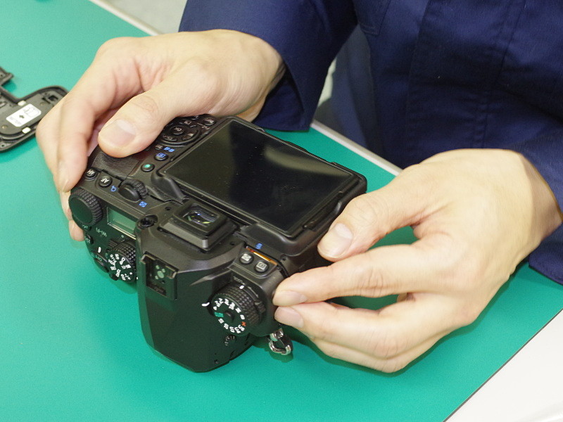 上下と背面のカバーを仮組みし、安定化電源に接続したテスト用のバッテリーをカメラに装填。内部回路のショートがないことを確認する。