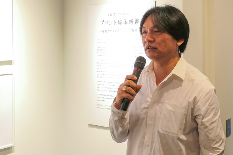 展覧会「プリント解体新書 -写真力を高めるプリントの秘密-」で自身の展示を解説する岡嶋和幸さん。