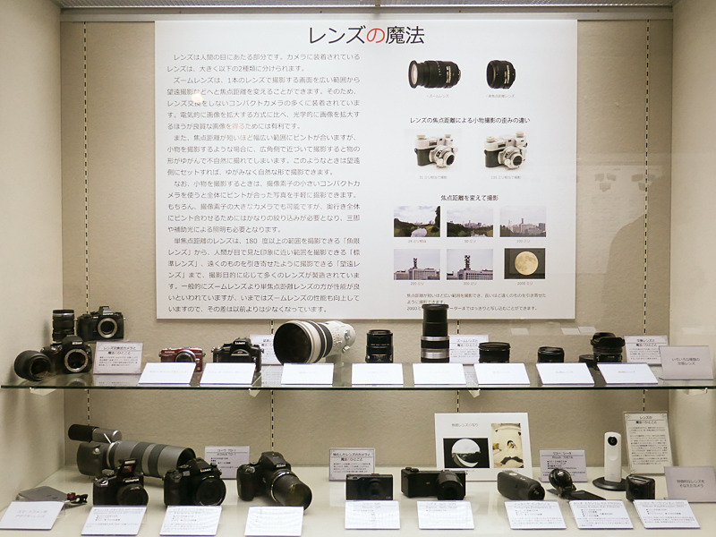 テーマ「レンズの魔法」。ズームレンズ、超望遠レンズ、3Dレンズ、魚眼レンズなど、様々なレンズが並ぶ。物の形状を自然に撮影するテクニックは、日常的なスマートフォンでの撮影にも役立つ。