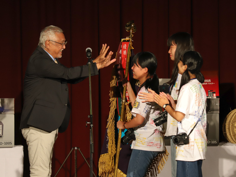審査委員長の立木義浩氏が優勝旗を手渡した。
