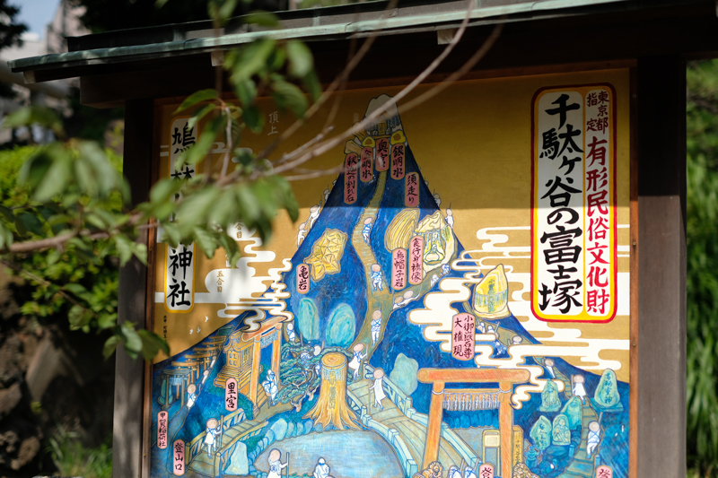 渋谷区千駄ヶ谷、鳩森神社にある富士塚。その案内図。<br><span class="fnt-85">X-Pro2 / XF35mmF1.4 R / 35mm（53mm相当） / 絞り優先AE（1/6,400秒・F2.0・±0.0EV） / ISO 200</span>