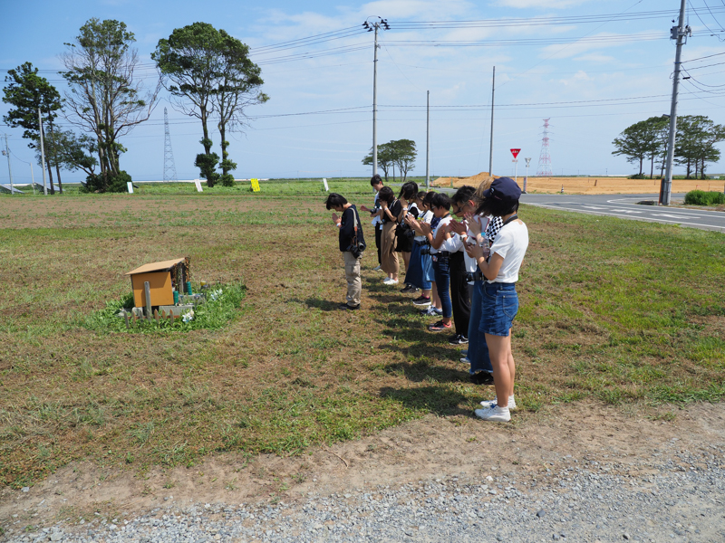 慰霊碑に手を合わせる参加者たち。