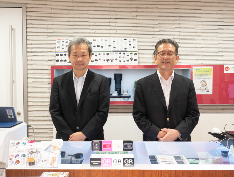 PRSPを担当するリコーイメージング株式会社カスタマーコミュニケーション部の狩野学さん（左）と、同じく原清文さん。