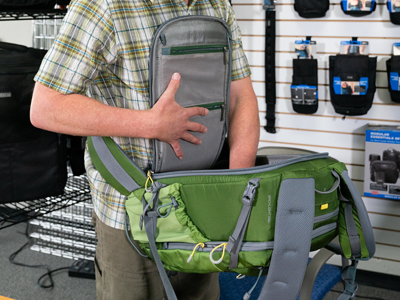 マインドシフトの「バックライト」シリーズは、バッグを地面に置くことなく背面アクセス可能。両手を使う場合、フラップはゴム紐で首にかけることもできる。