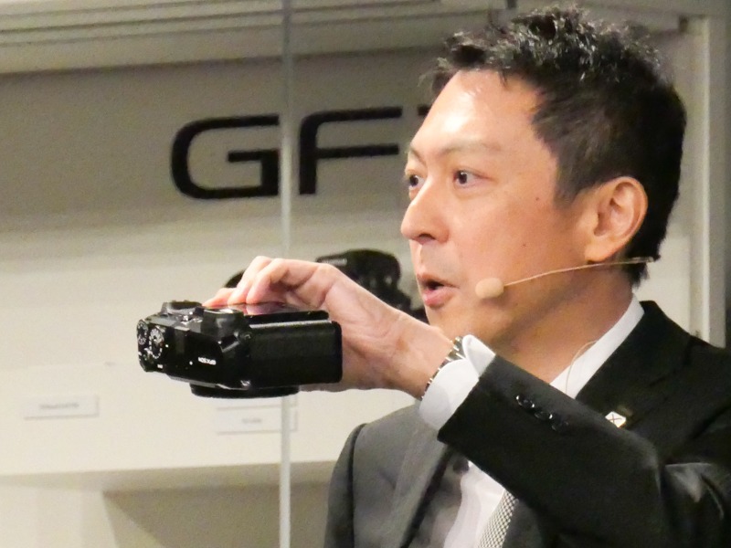 GFX 50Rを手に、ボディの薄さを示す。