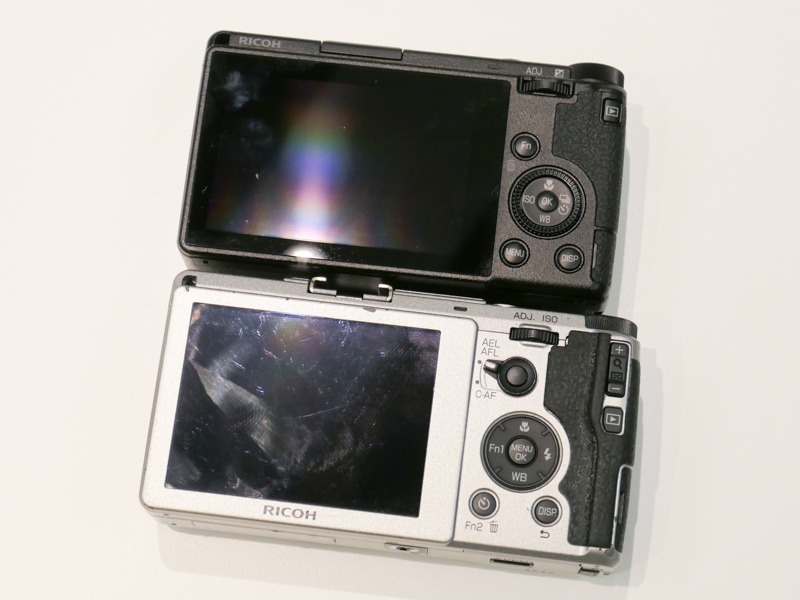 GR II（下）との比較。レバー押し込みによるADJ.メニューは踏襲されるそうだが、親指位置の上下キーはなくなった。露出補正はADJ.レバーがデフォルトになるようだ。方向キー周囲はホイールになった。