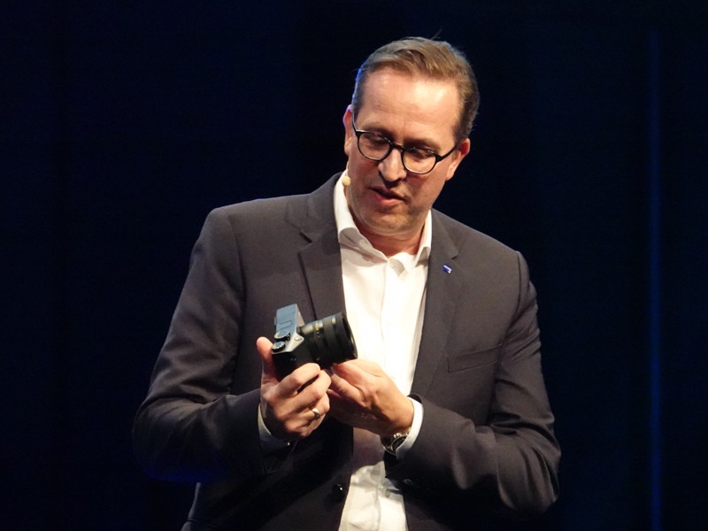 ZX1を手にする、独ツァイスのコンシューマ製品担当ヨルグ・シュミッツ氏。