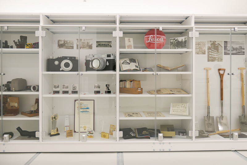 ライカカメラ現社屋の鍬入れを行ったスコップ（右端）など、さまざまなアイテムが並ぶ棚。