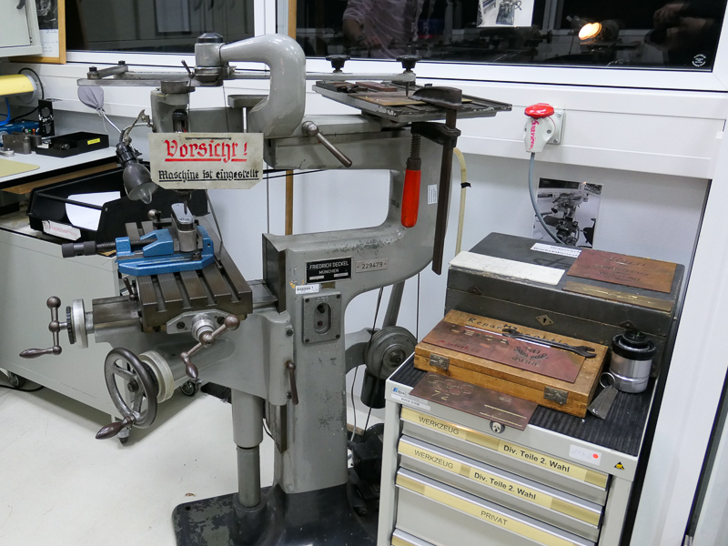 カメラのトップカバーに刻印する彫刻機。現行製品ではレーザー刻印だが、リペア用として今も残っている。