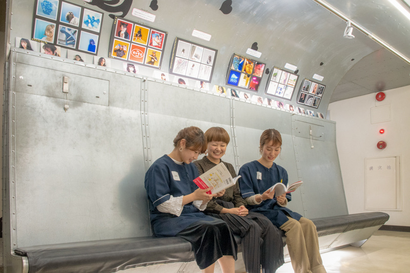 校舎内には講義の課題作品が飾られている。人物中央が矢島直美さん。