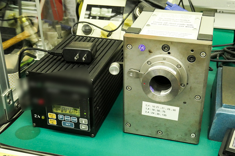 カメラ本体の距離計連動コロに接するレンズ側の「カム」の精度をチェックする機器。右の機器に連動して、左側の機器にコロの押され具合が表示される。