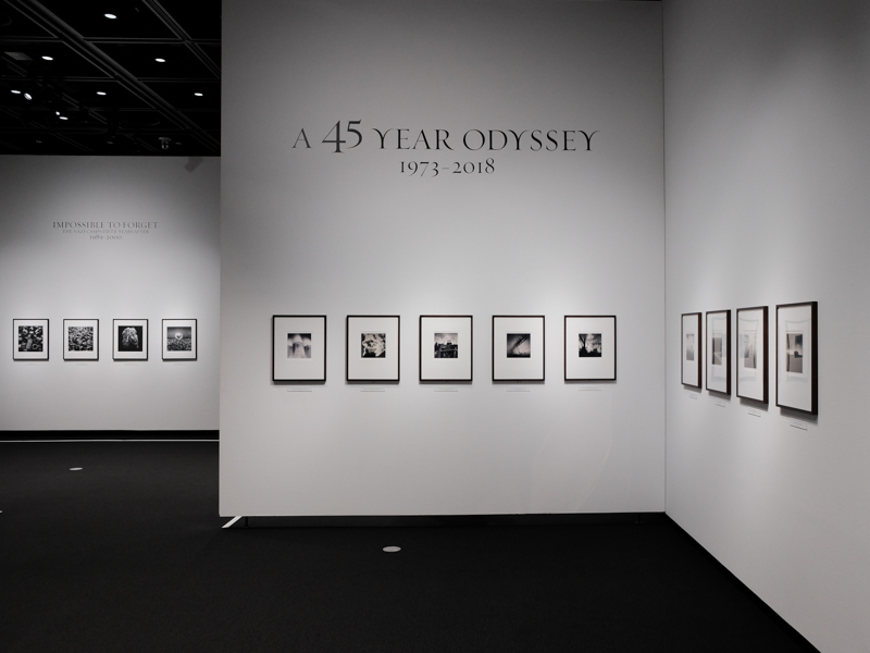 手前側に展覧会タイトル、奥の部屋に強制収容所シリーズのタイトルが見える。