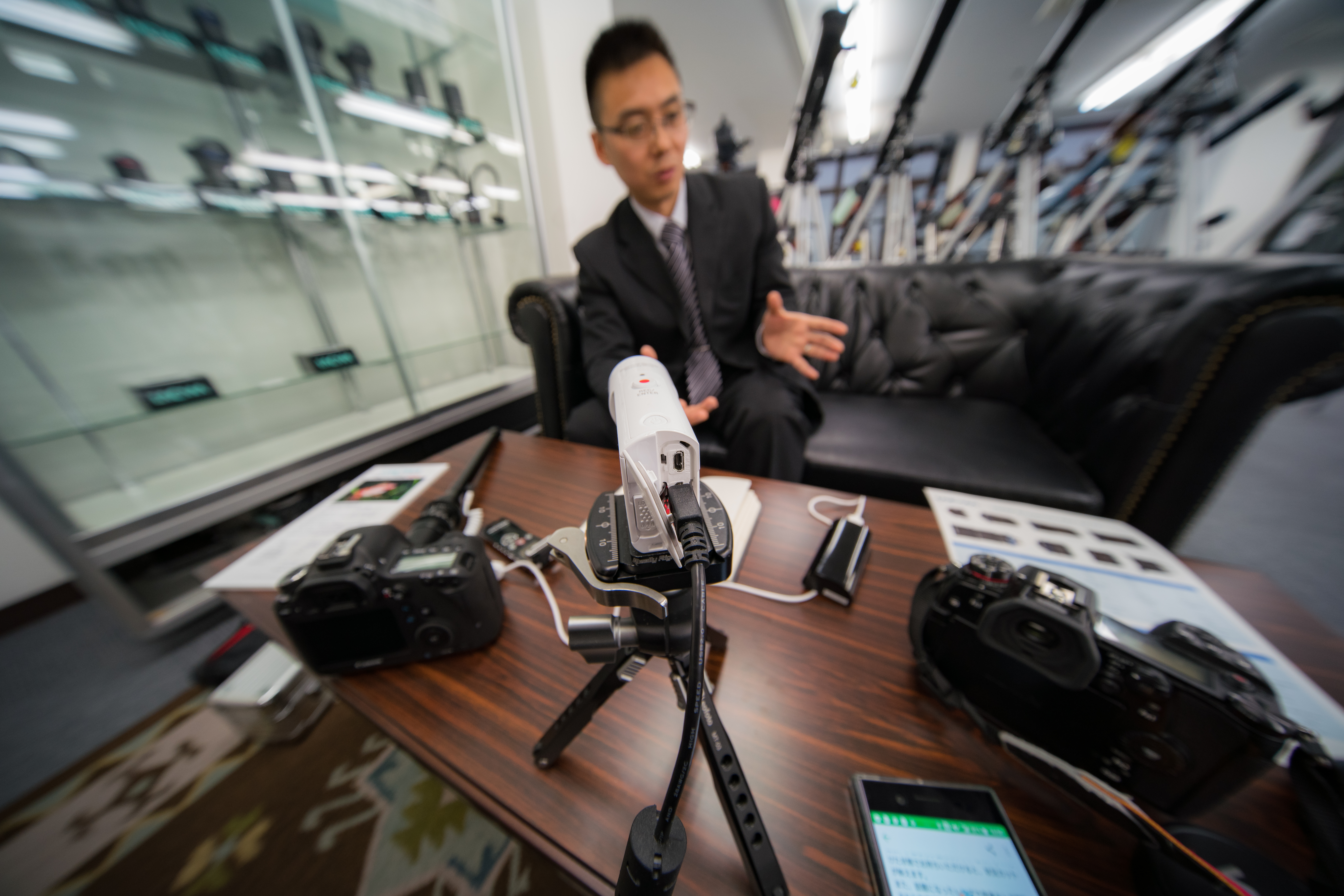 本レンズの最短撮影距離は15cmと短い。至近距離の白いカメラにピントを置くと、超広角らしいパースを感じる描写になった。