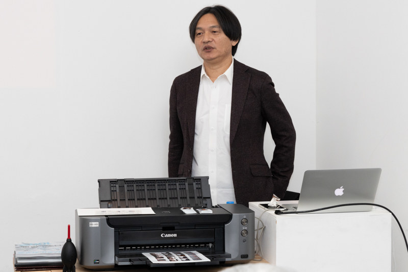 セレクト術・プリント術を指南する写真家の岡嶋和幸さん。