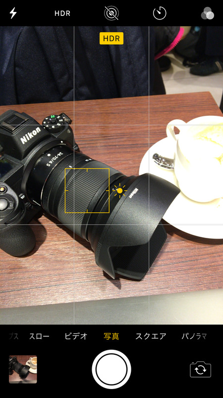 iPhoneの標準カメラアプリで「明るさのコントロール」をしてるところ。デジタルカメラでいうところの「露出補正」に近い機能。「グリッド」もONにしている。