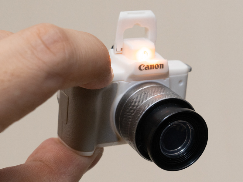 ホワイトの標準ズームモデルは、シャッターボタンを押すと光る（内蔵ストロボ発光部は光らない）。