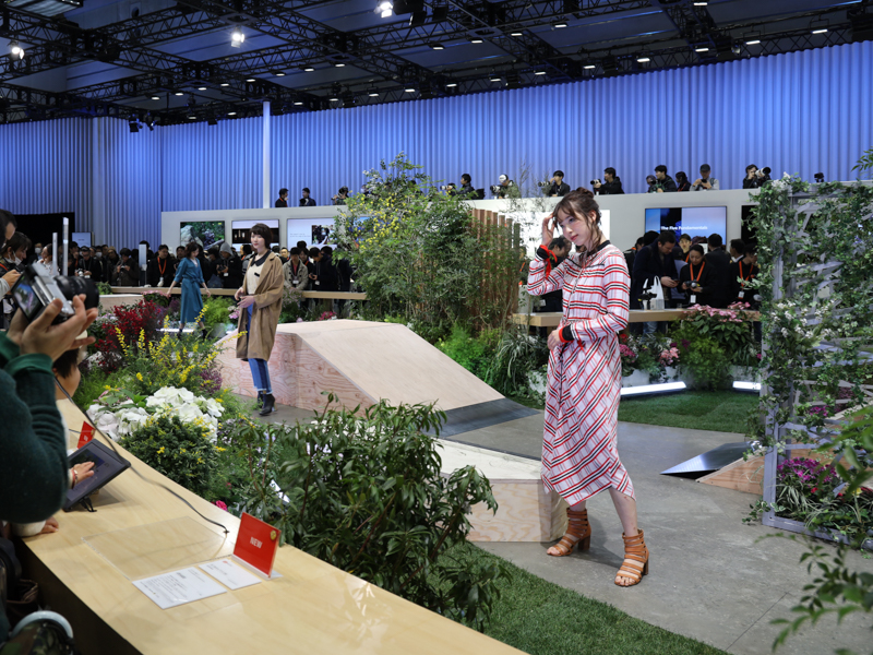 モデルの背後にみえるのは、望遠レンズの体験コーナーだ。