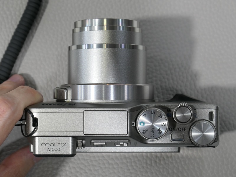 スリムタイプの高倍率ズーム機で、鏡筒わきにもズームレバーを持つのは珍しい。レバー上部のボタンは、一時的にズームアウトして被写体を見つけやすくする「クイックバックズームボタン」。