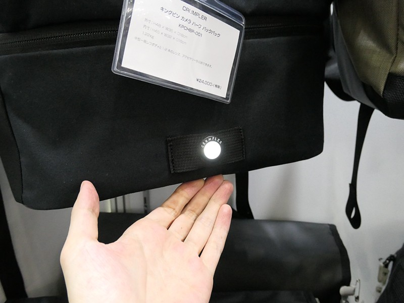 バッグ下部にLEDライトが備わる「キングピン カメラ ハーフ バックパック」（税込2万5,920円）。押すごとに点灯/点滅が切り替わる。