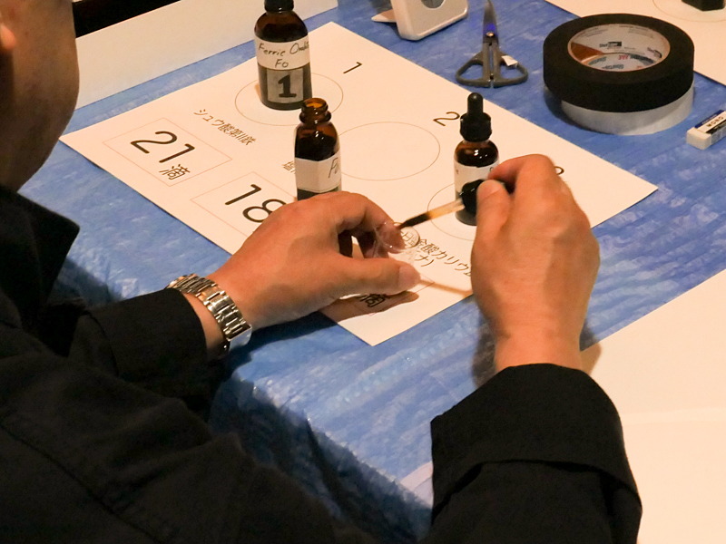 3つの液をスポイトで1滴ずつ数えながら混ぜ、紙の上に落とす。