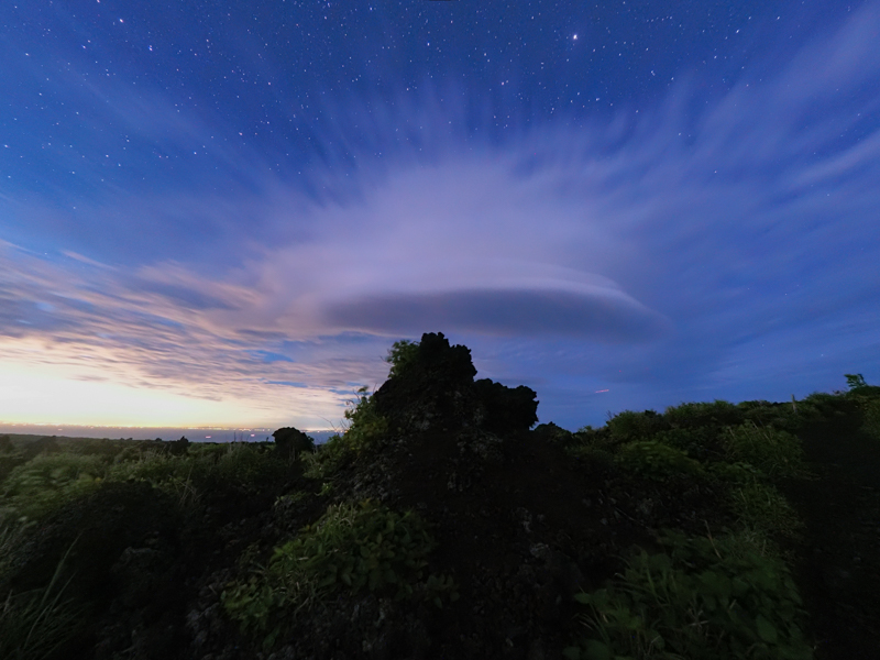 溶岩が固まってできた特徴的な形の岩の上に、あたかも笠雲のような面白い雲がかかった。フィッシュアイ補正機能を利用し、ゆがみをなくして撮影した（撮影：北山輝泰）<br><span class="fnt-85">OLYMPUS OM-D E-M1X / M.ZUIKO DIGITAL ED 8mm F1.8 Fisheye PRO / 8mm（16mm相当） / マニュアル露出（F2.8、30秒） / ISO 3200 / WB：4,000K</span>