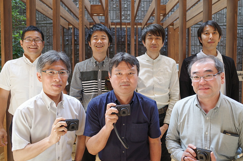 前列左から<br>株式会社リコーイノベーション本部 光システム応用研究センター 光学技術開発室 光学技術開発1グループ シニアスペシャリストの大橋和泰氏<br>株式会社リコー Smart Vision事業本部 カメラ事業部 商品企画部の荒井孝氏<br>株式会社リコー Smart Vision事業本部 カメラ事業部 デバイス開発部 設計51グループ サブリーダーの細川哲生氏<br><br>後列左から<br>株式会社リコー Smart Vision事業本部 カメラ事業部 デバイス開発部 設計61グループ スペシャリストの鈴木洋輔氏<br>株式会社リコー Smart Vision事業本部 カメラ事業部 デバイス開発部 設計51グループ スペシャリストの吉田教洋氏<br>株式会社リコー 知的財産本部 総合デザインセンターUXデザイン室 プロダクトデザイン4グループ プロダクトデザイナーの稲葉利弥氏<br>株式会社リコー Smart Vision事業本部 カメラ事業部 デバイス開発部 設計31グループ スペシャリストの宮田雅嗣氏