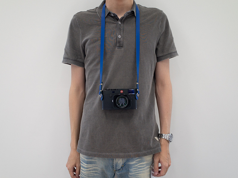 身長179cmの筆者が100cmタイプを首掛けしたところ。移動時などカメラが体の前でバウンドするのが気になる時は、左腕を通してカメラを斜め掛け状態にし、体に引き寄せる。