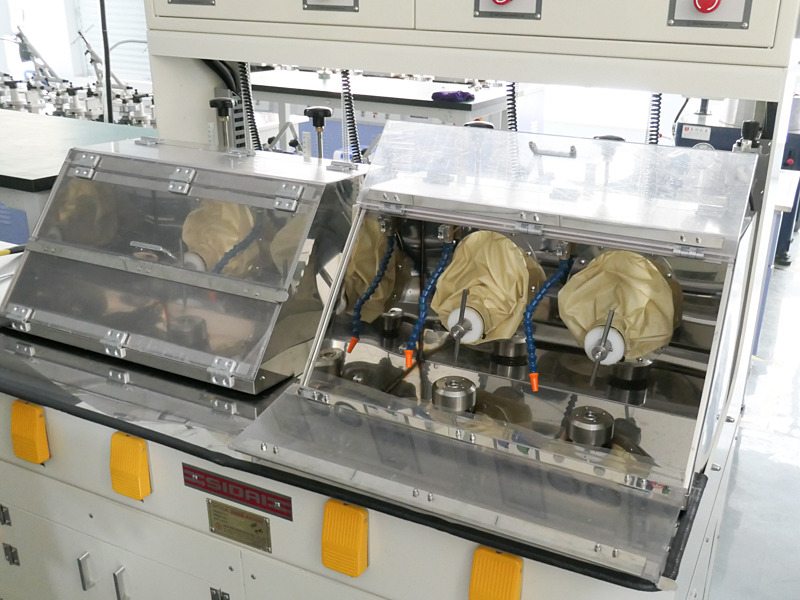 稼働前の研磨機を見たのは初めて。これはガラスを指定のカーブに加工する機械で、研磨材が飛び散らないようにドアがついている。