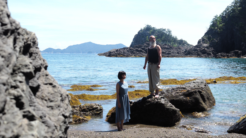 明丸海岸。ゴツゴツした岩肌の質感と海の青のグラデーションが単焦点レンズならではで詳細に表現されている。手前の岩と湾状になっている奥の海岸と島を写すことで奥行きを出した（撮影：田口るり子）。<br><span class="fnt-85">OLYMPUS OM-D E-M1 Mark II / M.ZUIKO DIGITAL ED 25mm F1.2 PRO / 25mm（50mm相当） / マニュアル露出（F4.5、1/800秒） / ISO 250 / WB：オート</span>