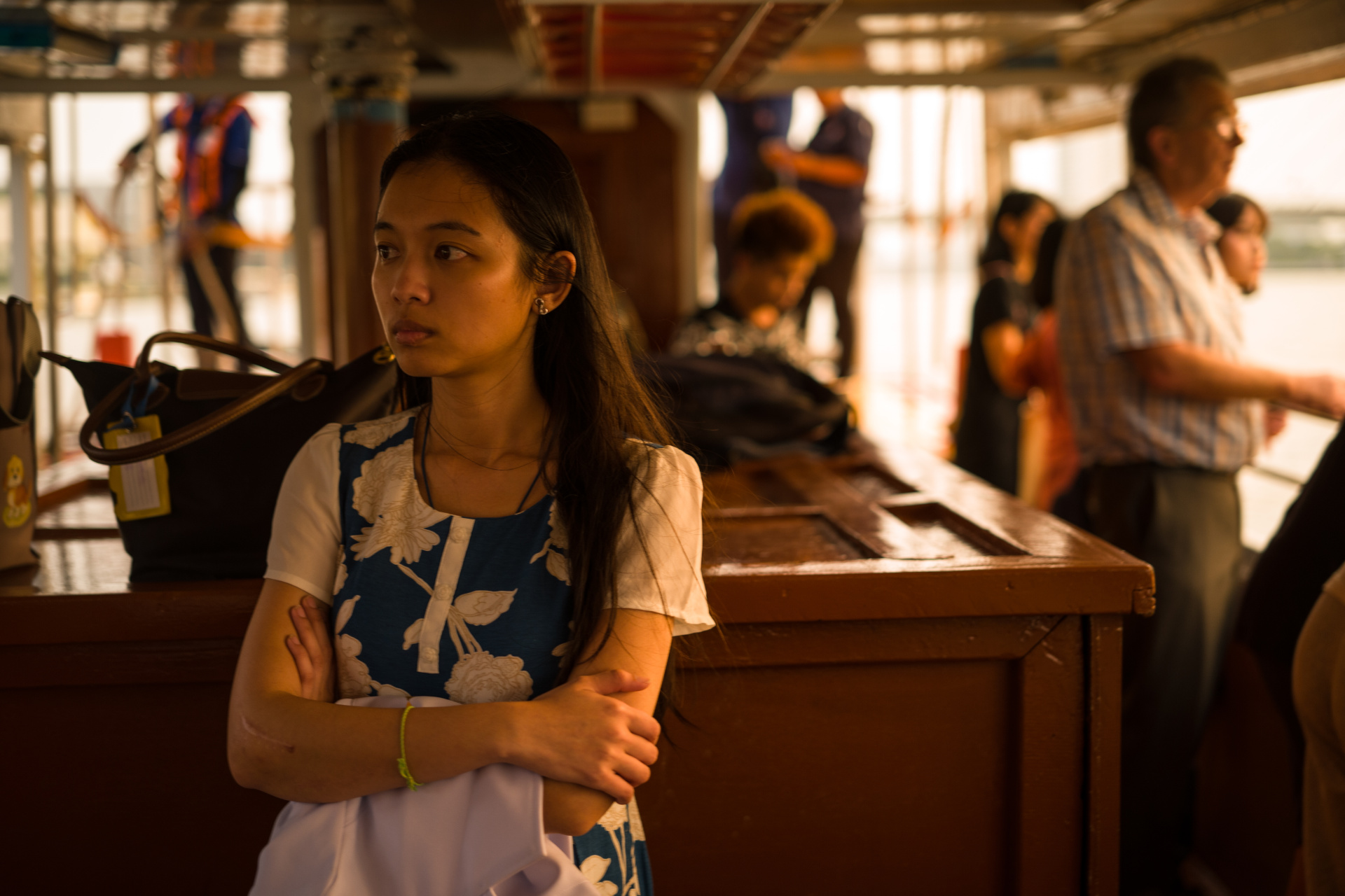 病院の白衣を手に、風に髪をなびかせ、遠くを見つめる女性。日没前後のエクスプレスボートには、仕事帰りの人が多く乗り込む。カメラを構える前に目測でおよそのピントを合わせておき、短時間でフォーカス&レリーズ。<br>LEICA M10-P　APO-SUMMICRON-M F2/50mm ASPH.　ISO 320　F2　1/60秒