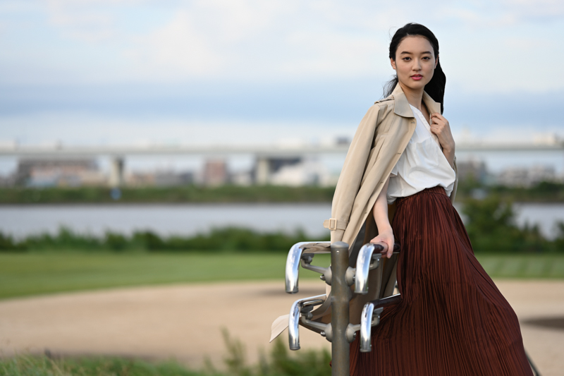 開放絞りのF1.8を使い、夕暮れ時の河原を背景に佇むモデルを撮影した。開放時でも十分な周辺光量が得られるので、画像周辺部で急に減光することはない。目で見た現場の空気感をそのまま写し込める。<br><span class="fnt-85">Nikon Z 7 / NIKKOR Z 85mm f/1.8S / 85mm / マニュアル露出（F1.8、1/1,250秒） / ISO 100</span>