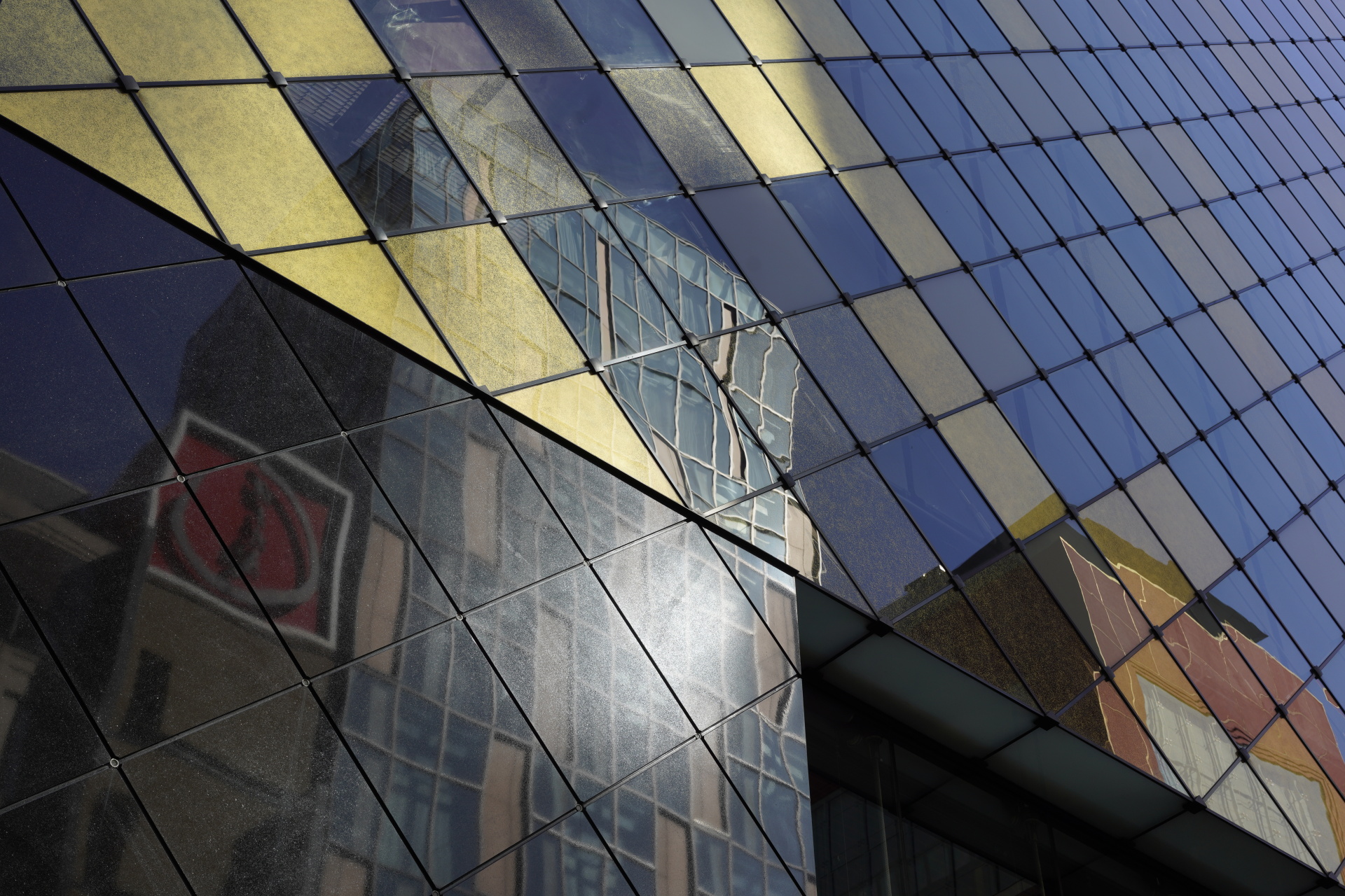 繁華街はガラス張りの新しい建物が多く、洗練された印象。反射する光が目に飛び込んできて、モザイクのようにきれいだったので切り取ってみた。もっと絞り込めばパンフォーカスになるが、これくらいの方が視覚に近く自然だ。<br>α7R IV　APO-LANTHAR 50mm F2 Aspherical E-mount　ISO 100　F8　1/250秒