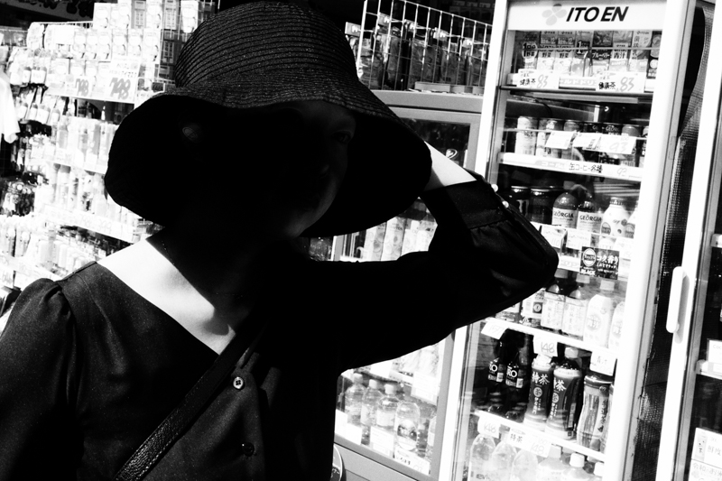 強い光のコントラストの中、前方から帽子を押さえながら歩いてくる人に、正確にピントを合わせ続けてくれた。そのお陰で構図を整えることに意識を向けることができたため、タイミングを合わせやすかった。<br>α6600 / E 16-55mm F2.8 G / 34mm（51mm相当） / マニュアル露出（1/1,000秒・F16） / ISO 2500