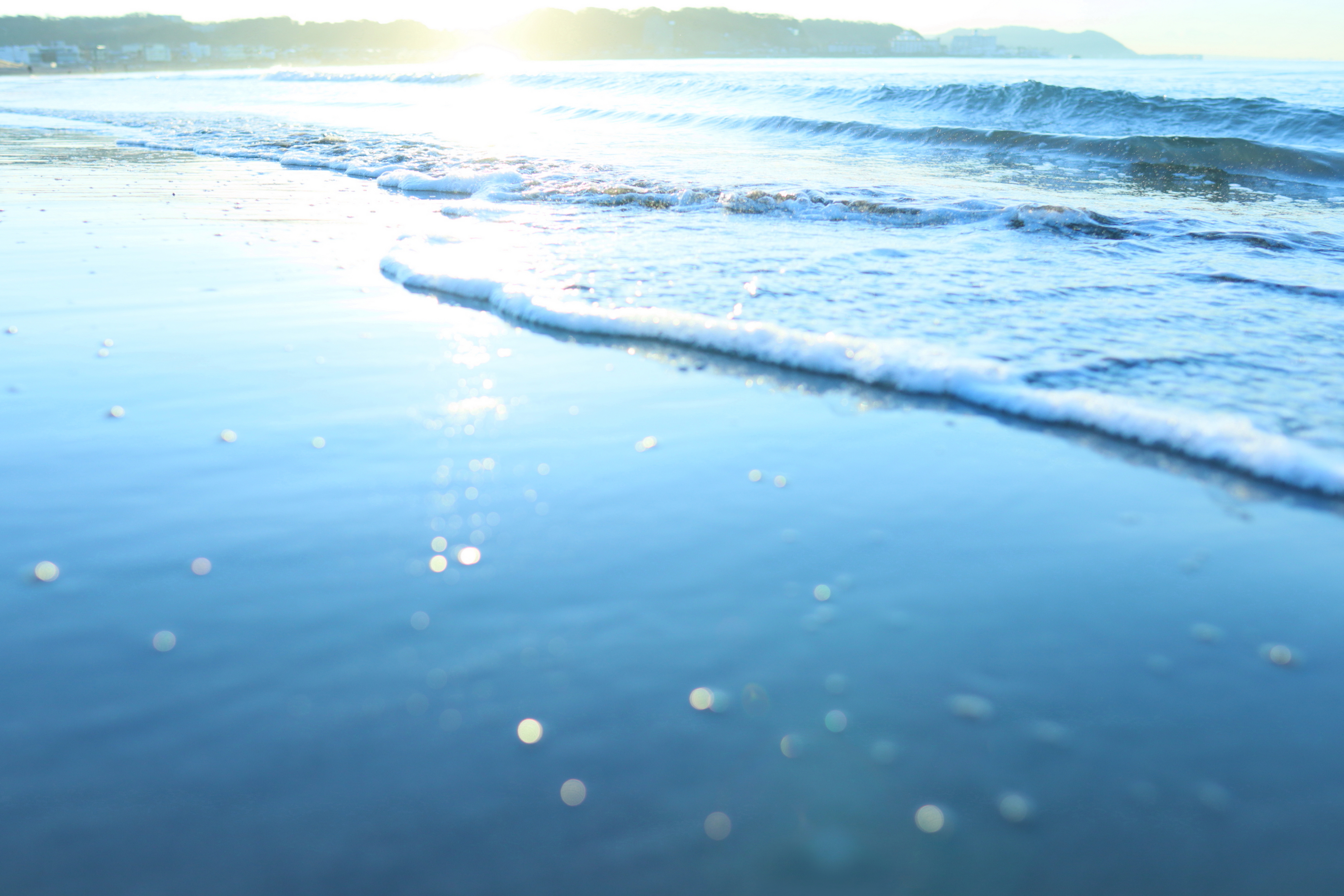 砂や貝が光を受けて反射してまあるい玉ボケを作る。このレンズのいいところの一つに、絞り開放でも玉ボケがまあるいところがある（他のレンズはたいてい楕円形で、ある程度絞り込まないと円形にならない）。<br><br><span class="fnt-85">EOS Kiss M / SIGMA 16mm F1.4 DC DN</span>