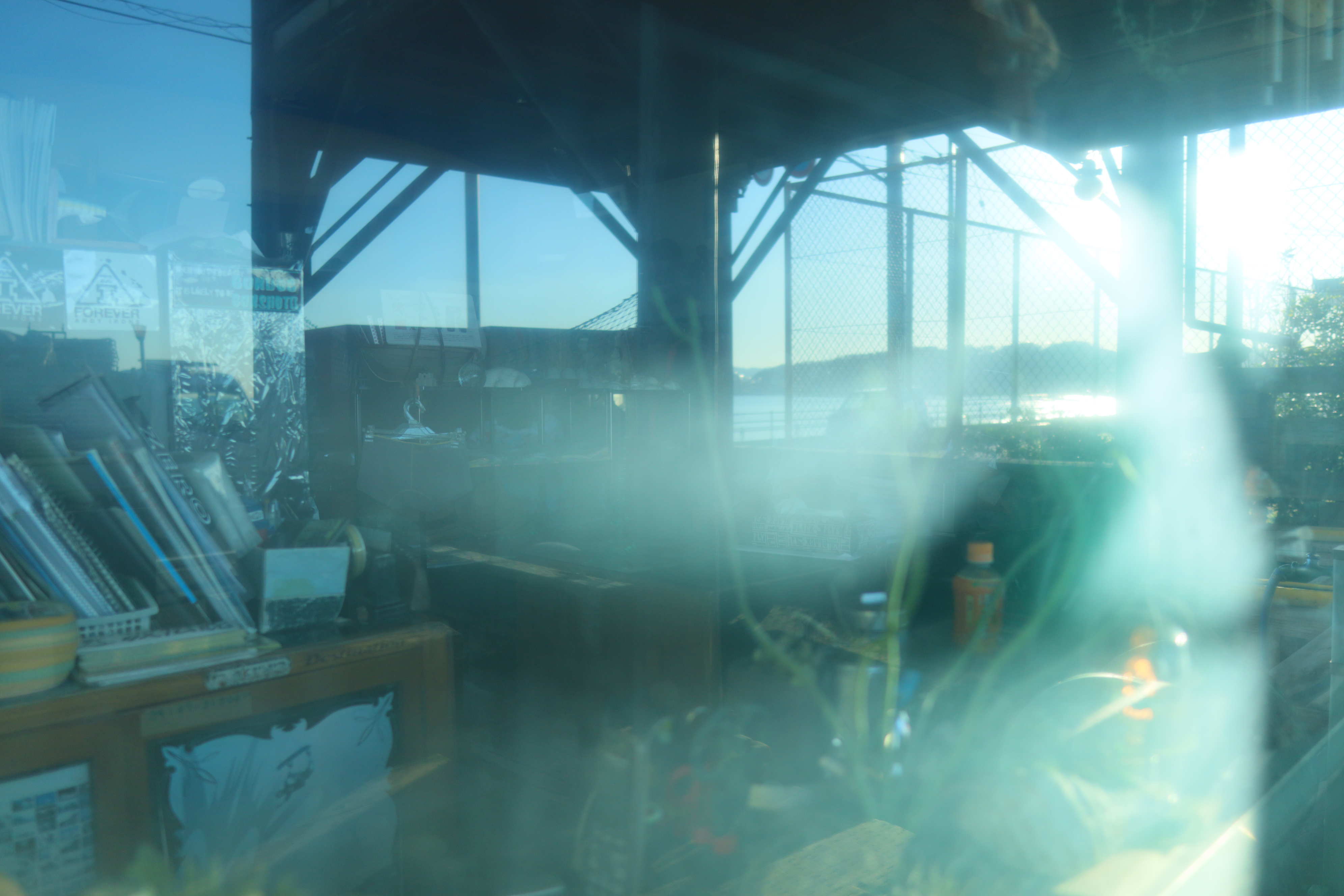 海辺のサーフィンショップはまだ空いていない。映り込みが含まれていてもAFは迷わずに捉える。カメラとのAFの相性はとてもよい。<br><br><span class="fnt-85">EOS Kiss M / SIGMA 16mm F1.4 DC DN</span>