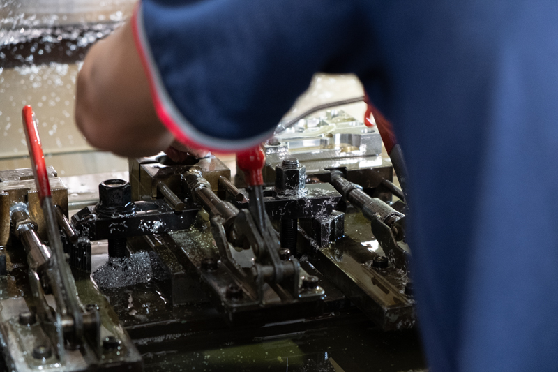 CNC加工機から整形されたパーツを取り出しているところ。右奥に整形されたパーツが見える