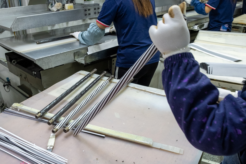 パイプに巻かれている白いものは、カーボンの巻数を示すための模様となるもの。この模様もカーボンシートを細くカットしたものだ