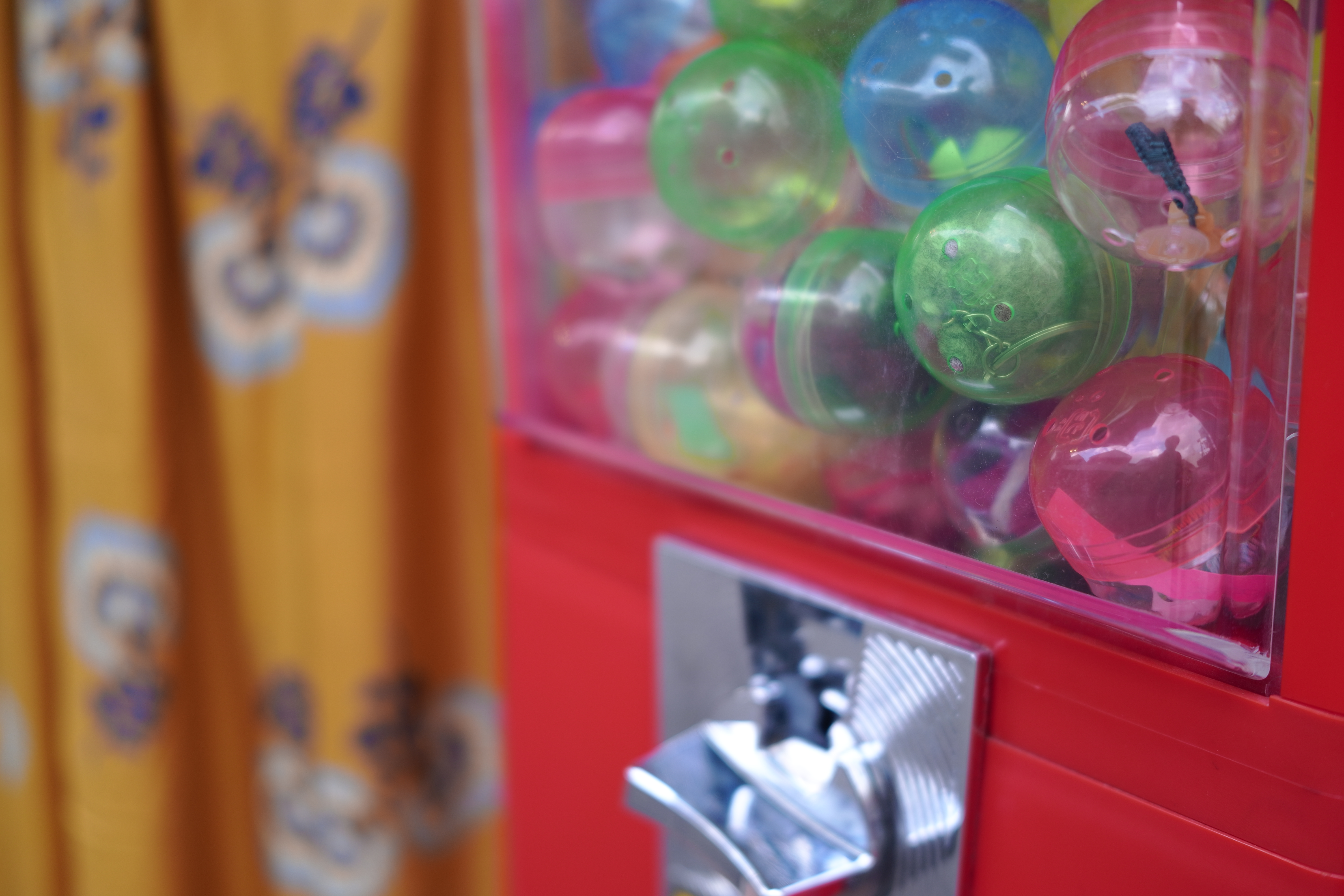 ガチャガチャや後ろの布がとても鮮やかだったので、色を強調するためにカラーモードをビビッドに設定した。SIGMAといえばRAWのイメージが強いが、fpはJPEG派も楽しめる。<br>SIGMA fp　45mm F2.8 DG DN　ISO 100　F2.8　1/125秒