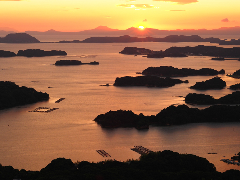 密集した島々のことを九十九島と呼ぶが、その島影を夕暮れの丘の上から狙った。太陽を画面に入れてもフレアやゴーストが発生しない点は特筆すべきだ（撮影：斎藤巧一郎）。<br><span class="fnt-85">OLYMPUS OM-D E-M5 Mark III / M.ZUIKO DIGITAL ED 45mm F1.2 PRO / 45mm（90mm相当） / 絞り優先AE（F8、1/60秒、-0.7EV） / ISO 200 / WB：6,000K</span>