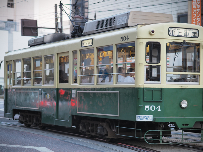 長崎市内には路面電車が走る。低速なので撮影しやすく、古い車両は絵になる。夕暮れの下校時、学生が乗車している車両を開放絞りで柔らかく撮影（撮影：斎藤巧一郎）。<br><span class="fnt-85">OLYMPUS OM-D E-M5 Mark III / M.ZUIKO DIGITAL ED 45mm F1.2 PRO / 45mm（90mm相当） / 絞り優先AE（F1.2、1/500秒、±0EV） / ISO 200 / WB：オート</span>