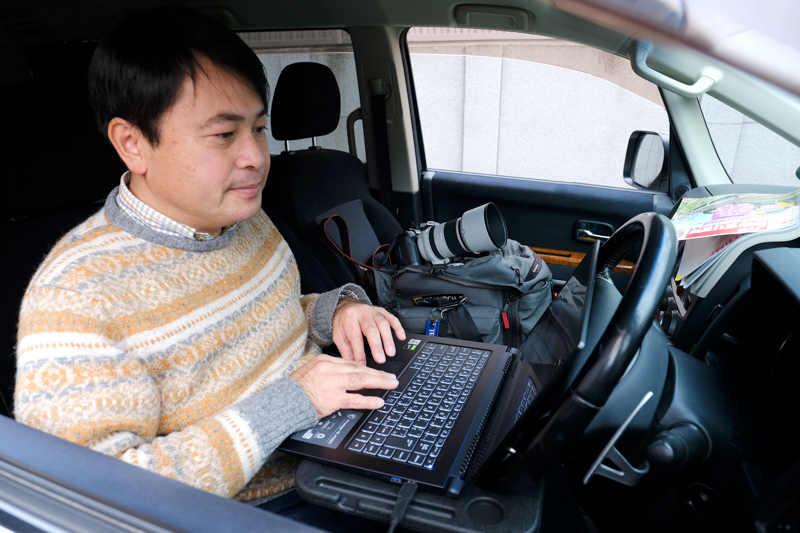 こんな風に愛車の運転席で作業するのだとか。映り込みが少ない非光沢ディスプレイがありがたいとのこと。