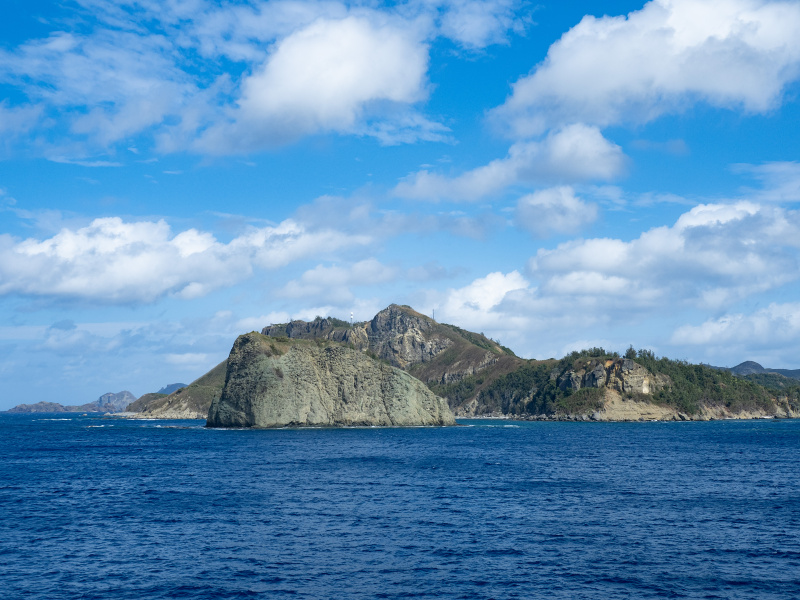 東京のJR浜松町駅にほど近い竹芝桟橋より、貨客船「おがさわら丸」に乗船しおよそ24時間かけて太平洋を一路南下するとようやく小笠原の島々が見えてくる。小笠原に近づくにつれ海の色がボニンブルーと呼ばれる深い青に変化していくことに気がつく。<br>OLYMPUS OM-D E-M5 Mark III / M.ZUIKO DIGITAL ED 12-100mm F4.0 IS PRO / 23mm / 絞り優先AE（F4・1/2,500秒・+0.3EV） / ISO 200